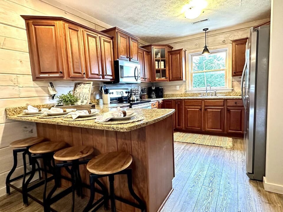 Kitchen has additional seating and plenty of cookware and dinnerware