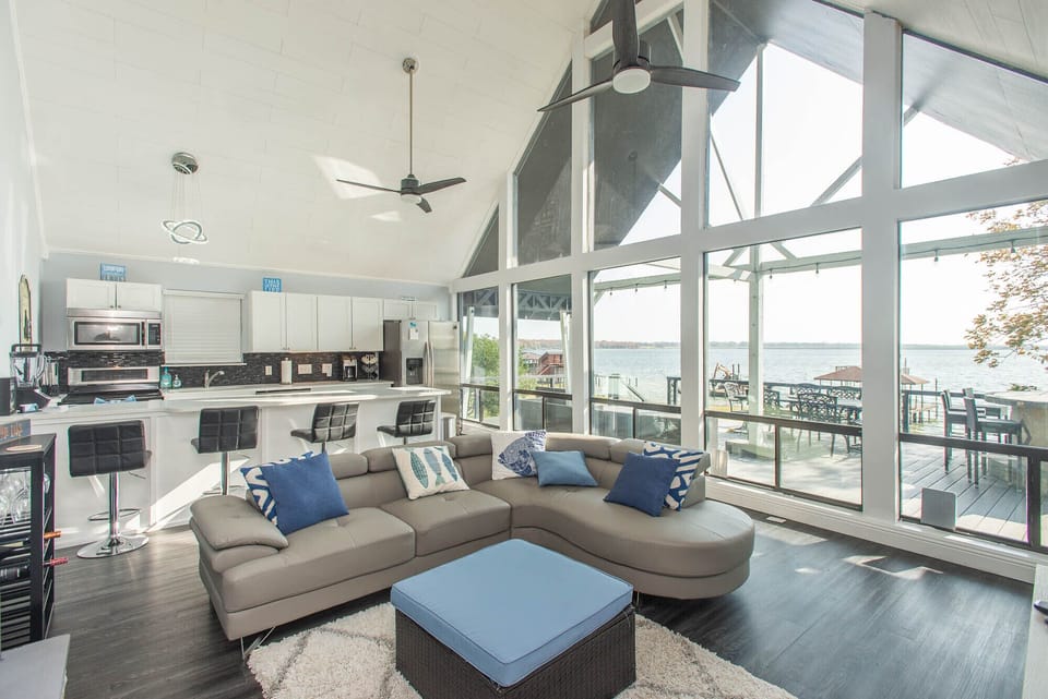 The great room of this A-frame home features a wall of windows with lake views!