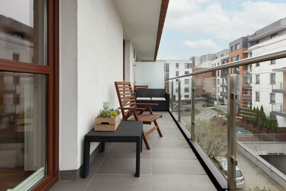 A private balcony with comfortable seating and a view of the modern neighborhood, perfect for relaxation.