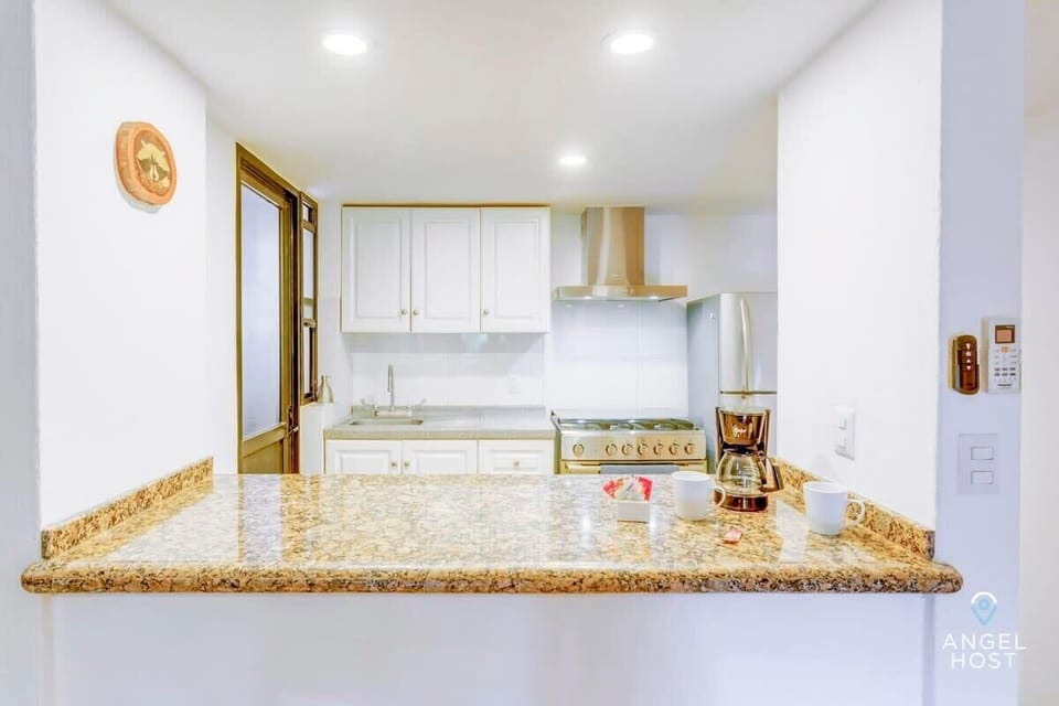Fully equipped kitchen including a fridge and stove.