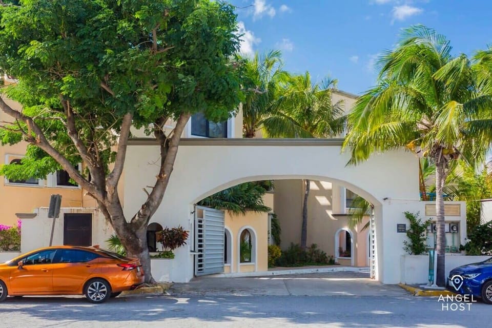 The front facade of the complex with a charming gated entrance with tropical vibes.
