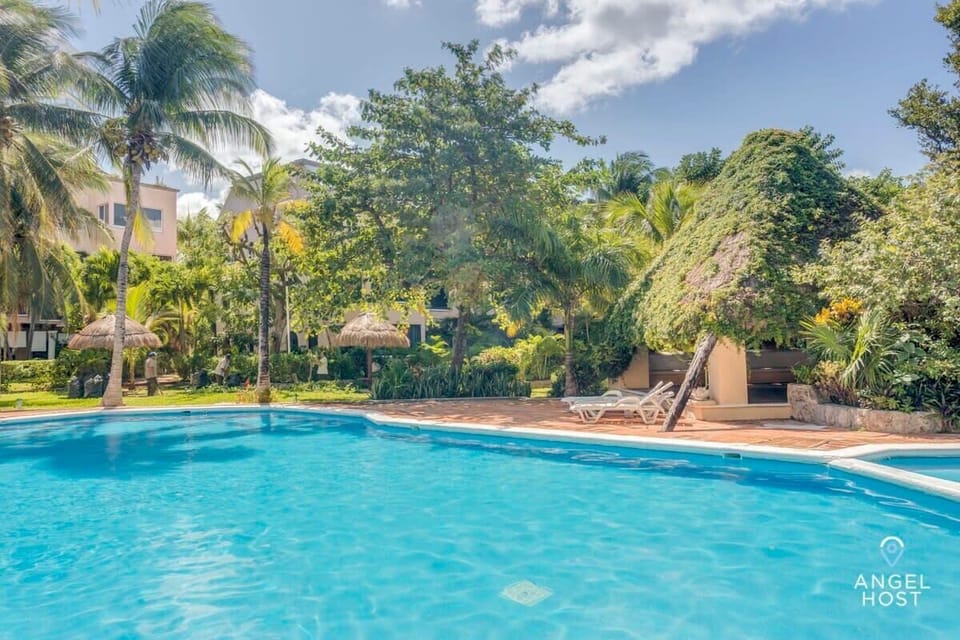 Start your day with a refreshing dip in the communal pool, surrounded by lush greenery.