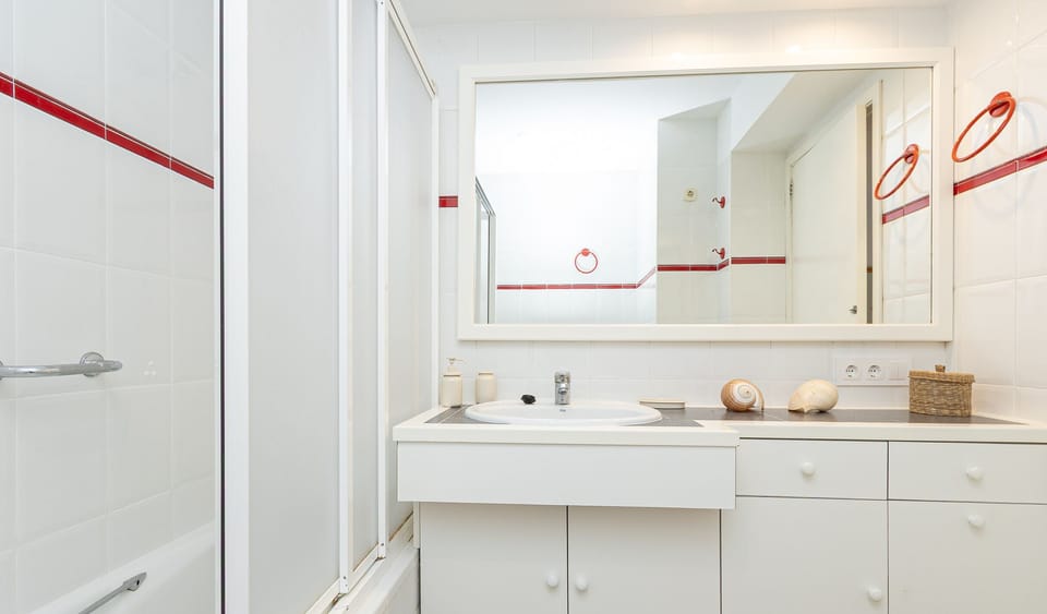 Full bathroom with bathtub, large sink and big mirror.