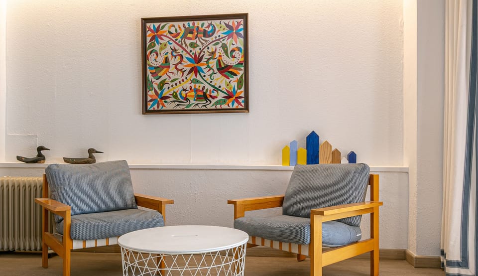 Living room corner with two armchairs, round side table and artistic decoration