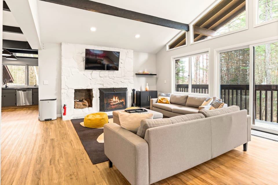 Cozy Living Room with Fireplace and large windows that frame peaceful views.