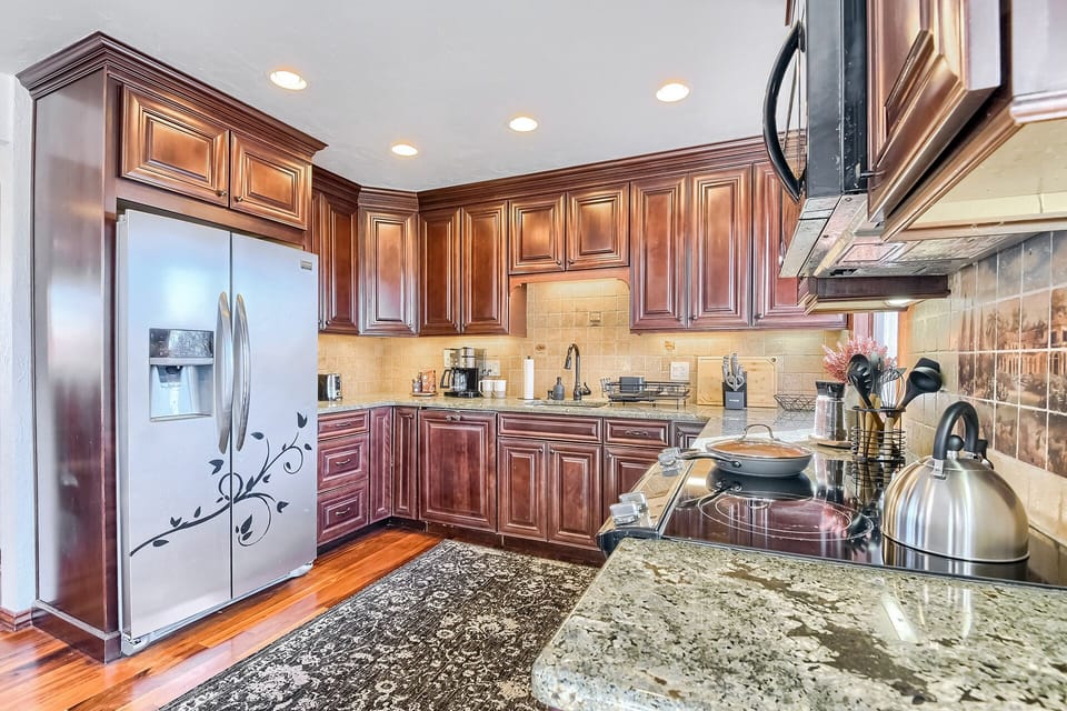 Kitchen with stainless steel appliances and full set of cookware