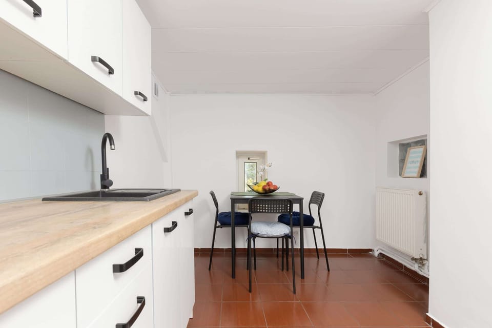 A modern kitchen with white cabinets, ample countertop space, and equipped with all necessary appliances.
