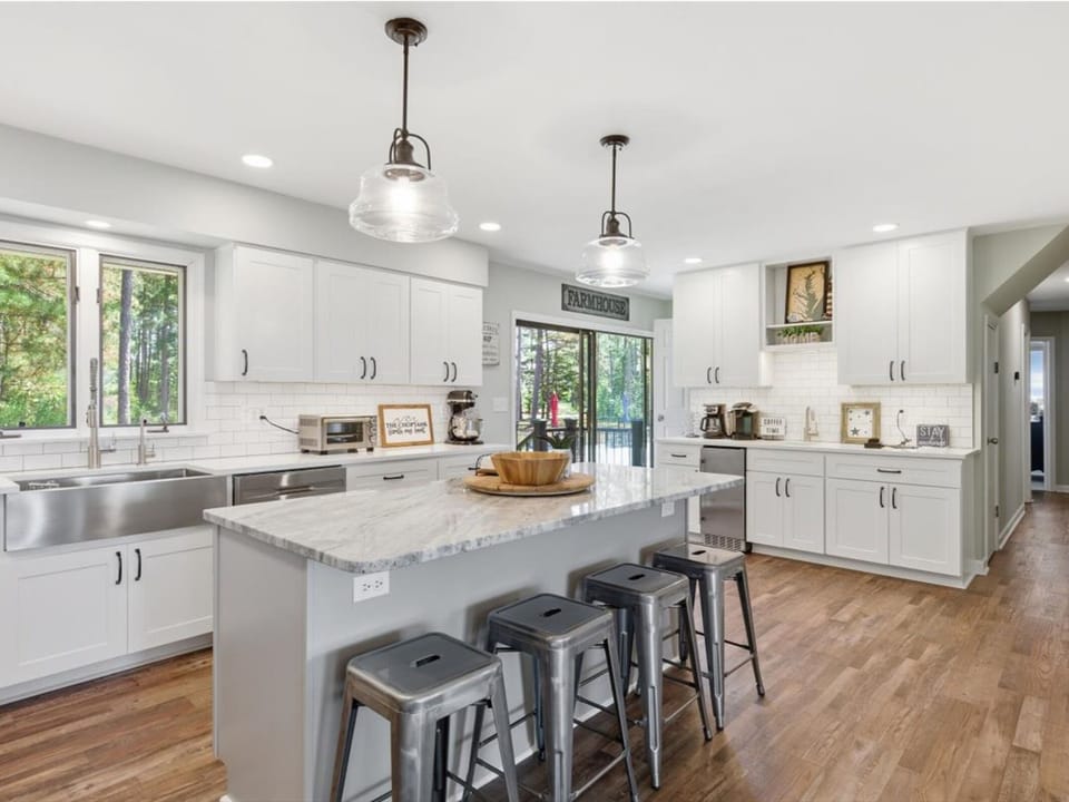 Your fully equipped kitchen awaits with bright natural light, spacious countertops, and modern appliances—perfect for preparing meals while enjoying peaceful forest views through the windows.