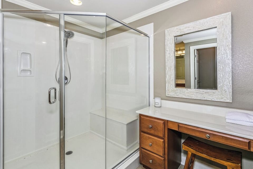 Refresh after a long day in your private bathroom with a spacious walk-in shower and warm wood vanity.