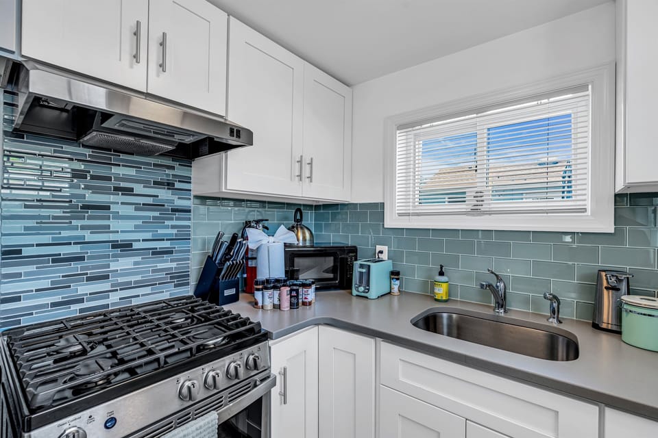Cook for the group without losing the conversation. White shaker cabinets stocked with oils and spices, gas range, Keurig combo coffee maker already loaded, knife block sharpened.