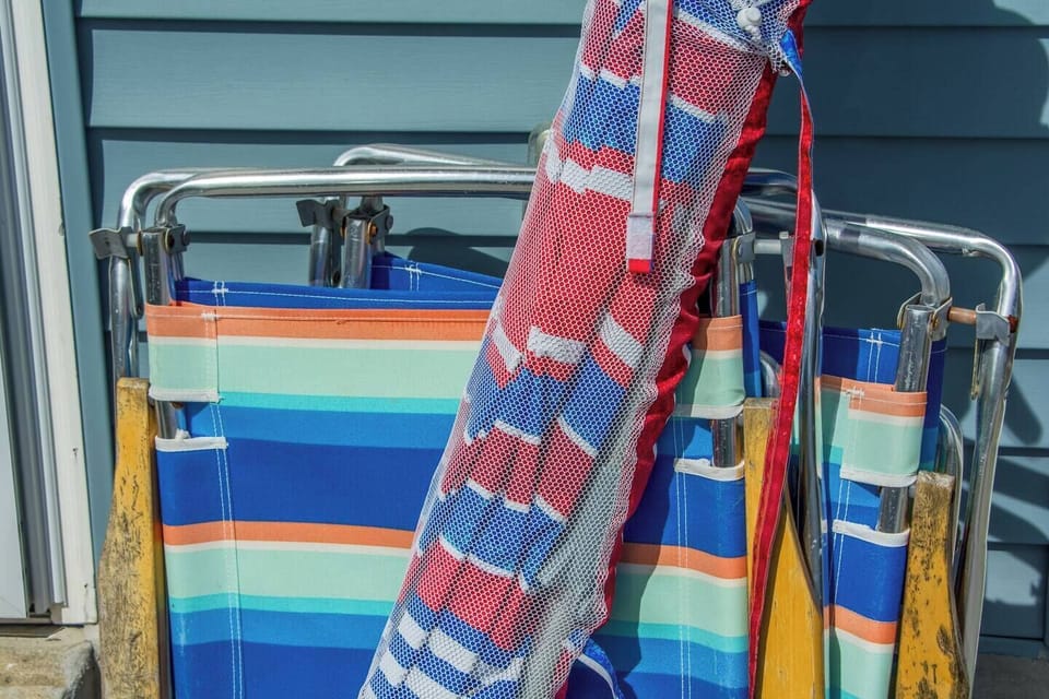 Grab the vintage beach chairs and striped umbrella on your way out the door. They stay with the house, no rental-stand line.