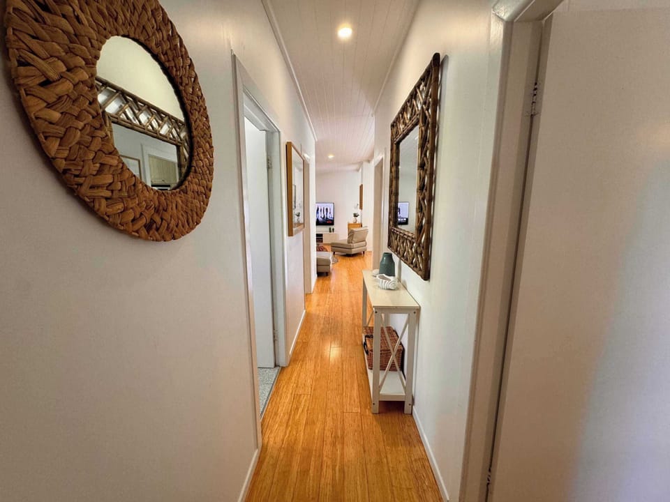 Hallway leads from main living area to three separate bedrooms and bathroom