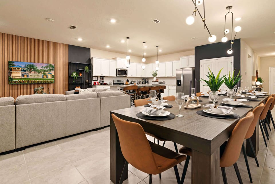 Elegant open-plan dining and kitchen area perfect for gatherings, featuring a large table and modern design.