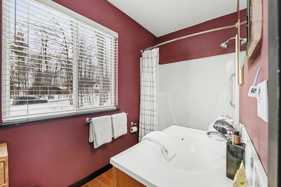 Bathroom with soaking tub and red walls at Sugarloaf Chalet in Arcadia, Michigan