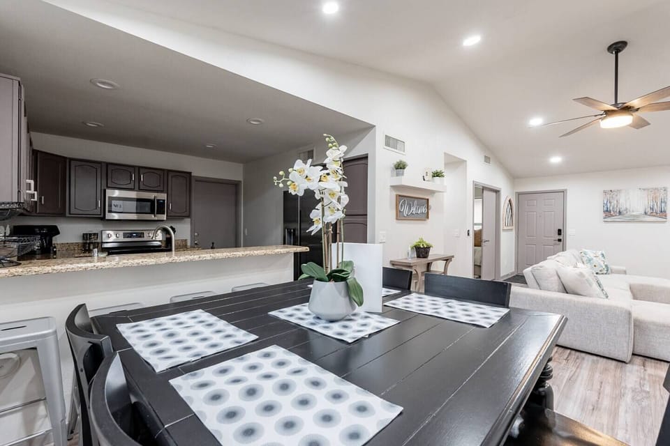 Step into an open floor plan connecting living, kitchen, and dining areas with extra seating at the kitchen bar.