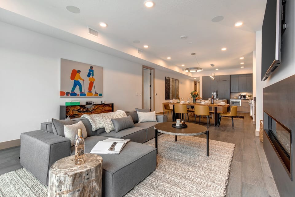 Living Room with sectional, Smart TV, gas fireplace, and private balcony access