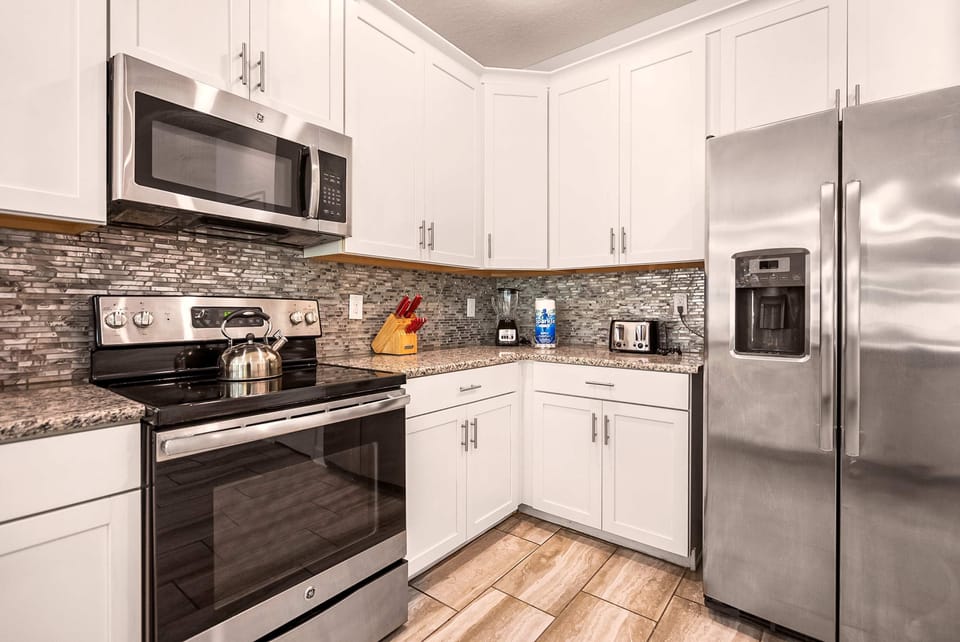 Modern kitchen with sleek stainless steel appliances and stylish granite countertops, ideal for culinary enthusiasts.