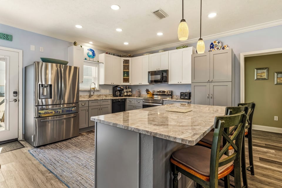 Your fully equipped kitchen features granite counters, stainless appliances, and a spacious island where you'll love preparing meals together.