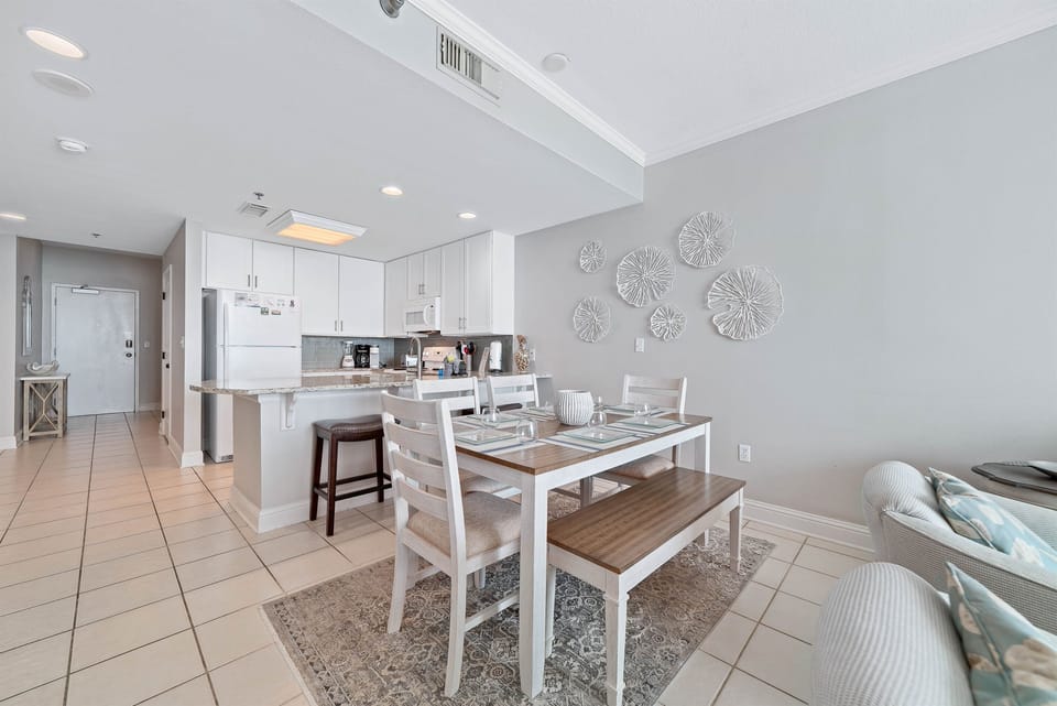 Dine in style with ample space for everyone. This inviting dining area features a charming table for family meals, complemented by additional seating at the convenient breakfast bar.