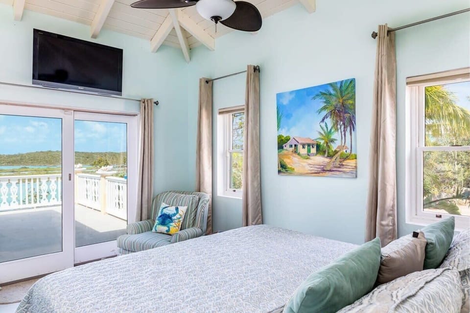 Bedroom features a king size bed, access to the terrace and a wall-mounted Smart TV.