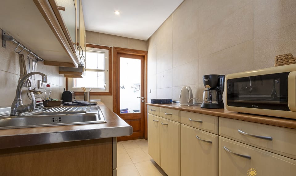 Kitchen with direct outdoor access, fully equipped for your stay.