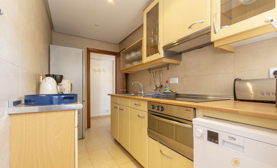 Functional kitchen with oven, dishwasher and full utensils.