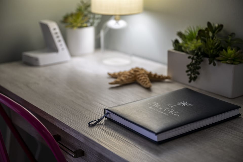 The primary bedroom offers a dedicated desk space, perfect for remote work or planning your next adventure. Stay productive while enjoying a glimpse of paradise just outside your window.