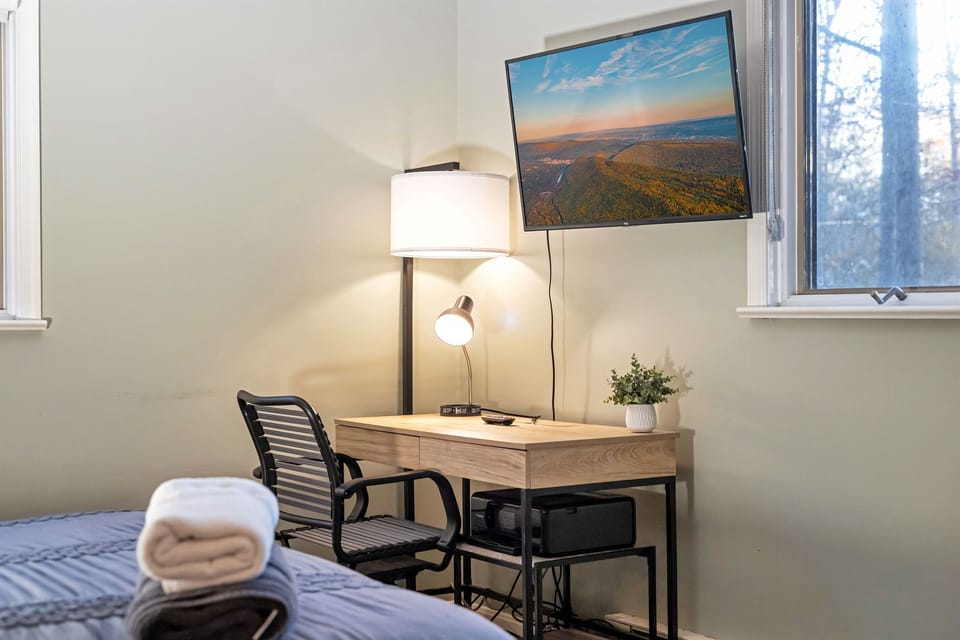 Cozy small workspace located in one of the bedrooms, featuring a simple desk and chair, ideal for remote work or quiet study
