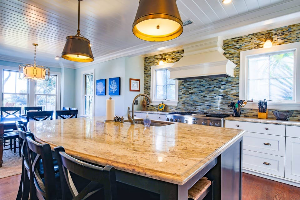 The kitchen centers around the island with granite counters, pendant lighting and 6 stools.