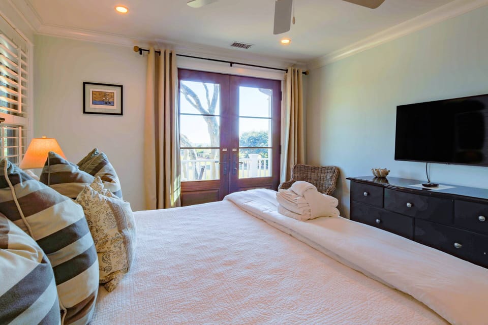 This lower primary suite has a king bed, dresser and mounted TV.