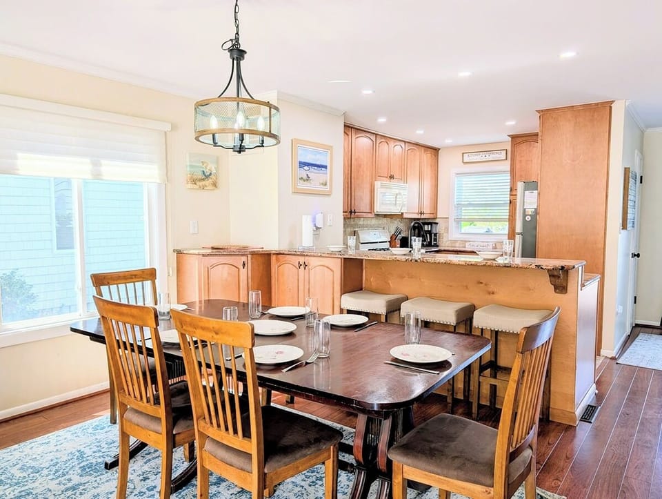 39562 Admiral Road, Tower Shores, North Bethany - dining - The well-appointed kitchen features warm wood cabinetry and a breakfast bar that opens directly into a dedicated dining area with a classic wooden table.