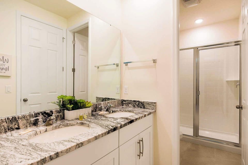 Elegant bathroom with double vanity and sleek granite countertops, perfect for a relaxing stay.
