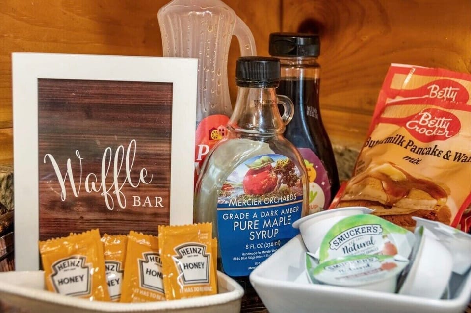 Our cabin’s kitchen features a delightful waffle bar and a well-stocked coffee station as part of the amenities.