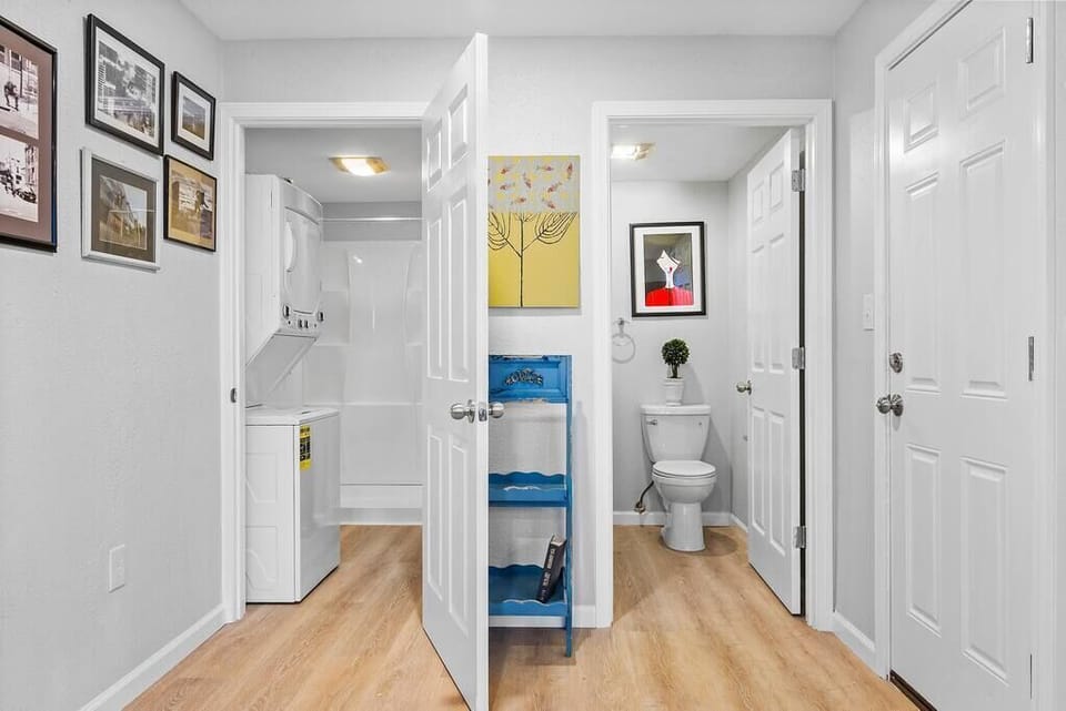 A view of the bathroom(s).  There is a separate toilet and vanity area, and the other side is a full size shower with a washer and dryer
