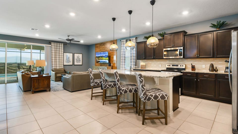 Beautiful open kitchen with granite countertops, stylish pendant lighting, and bar seating overlooking the living area.