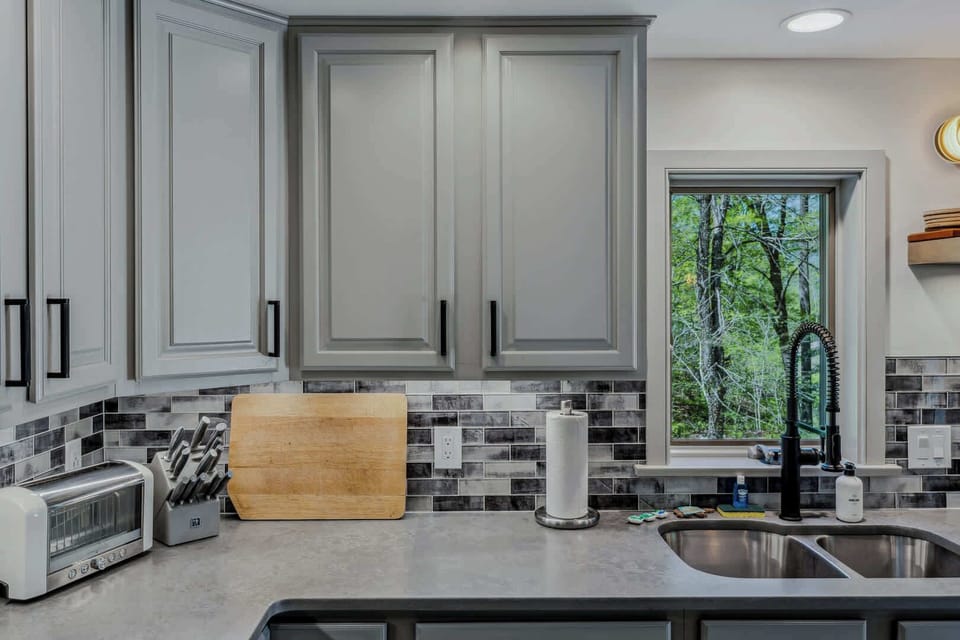 Kitchen details: fully stocked with cookware, knife set, and wooded window views