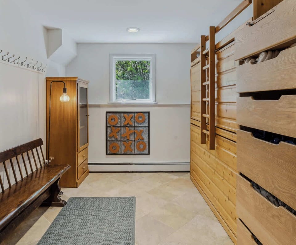 Bunk room with built-in bunks, toy storage, and playful wall art