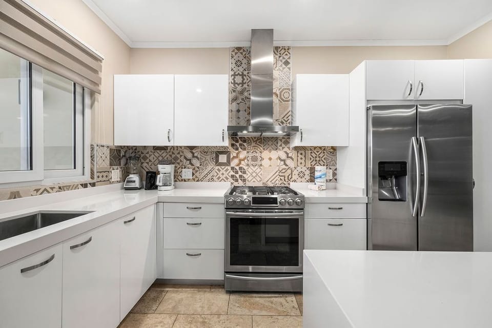 Full kitchen with fridge, stove, oven, coffee maker, electric kettle, microwave oven, and kitchen bar/counter.