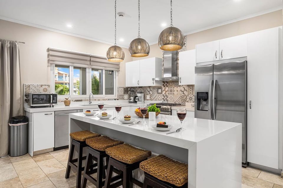 Full kitchen with fridge, stove, oven, coffee maker, electric kettle, microwave oven, and kitchen bar/counter.