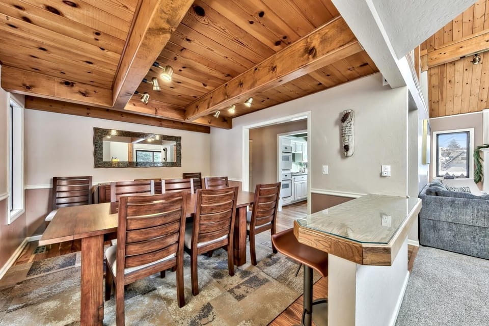 Gather around this stunning dining table beneath warm wood beams for memorable meals with your group.