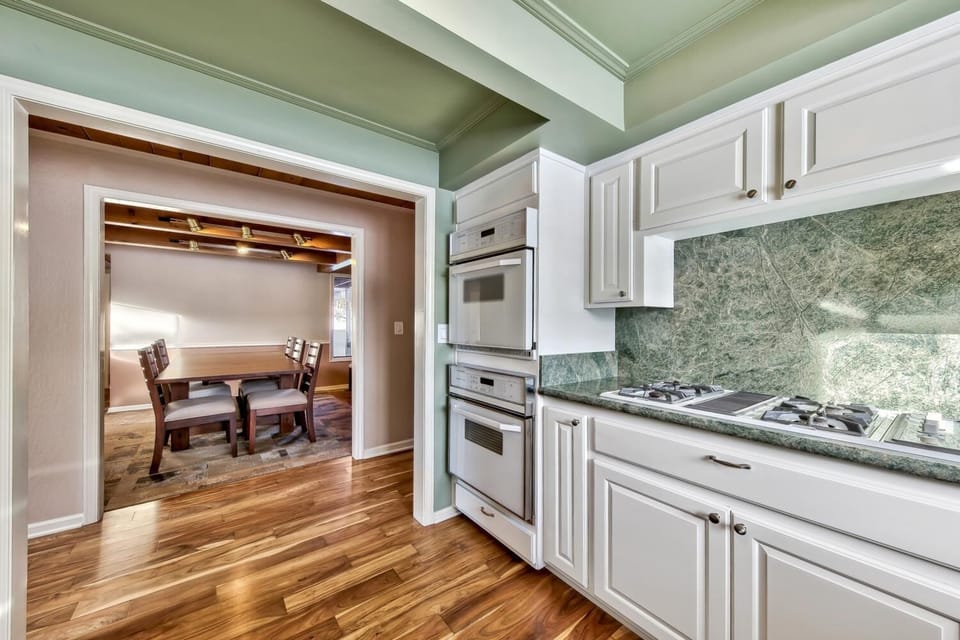 Cook your favorite meals in this elegant kitchen featuring granite countertops, stainless appliances, and classic white cabinetry.