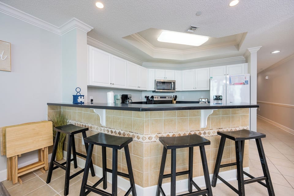 Enjoy morning coffee at the breakfast bar, feeling the inviting vibe of your beach getaway as the day begins