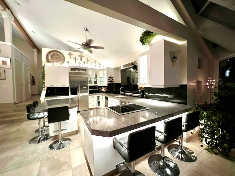 Kitchen has 6 bar stools, vaulted ceilings, hot water spout and glass ceilings.
