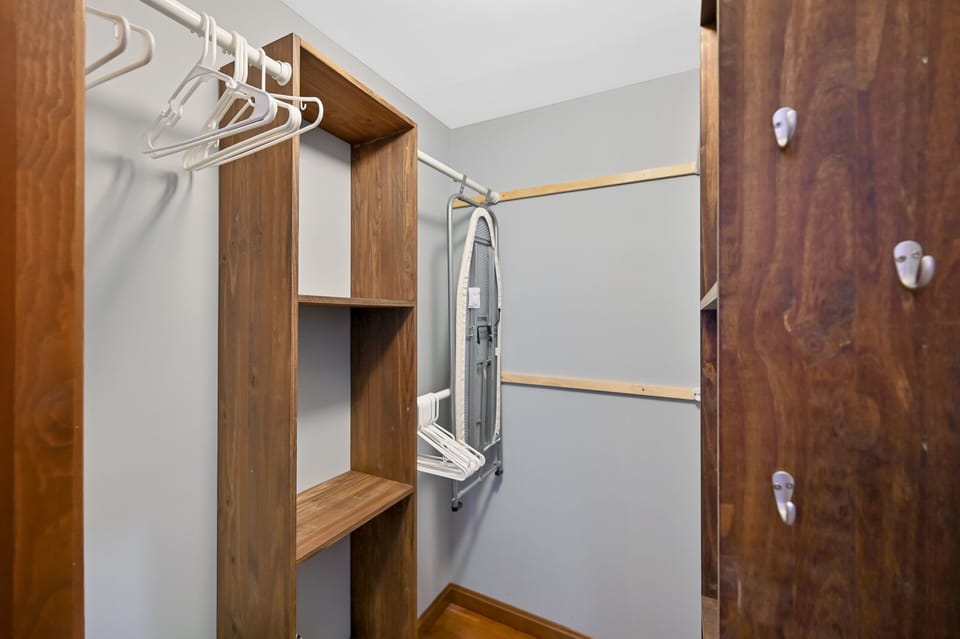 Master bedroom closet with iron and ironing board for guests use