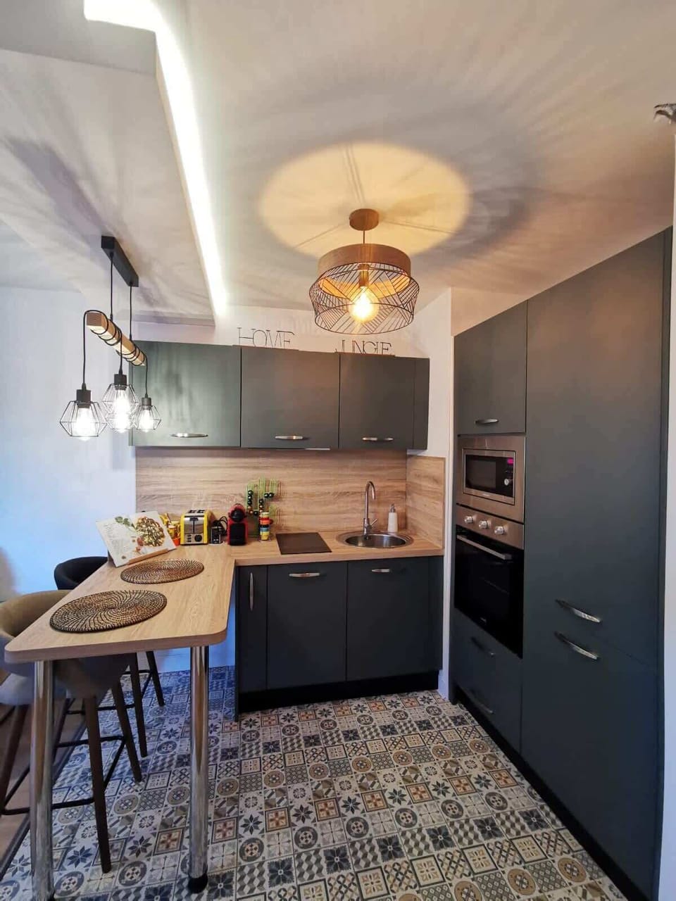 Cuisine américaine moderne avec four, plaque induction, lave-vaisselle et carreaux de ciment au sol