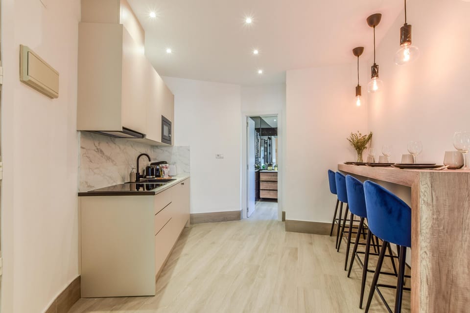 Main view of kitchen space with appliances and high top dining table
