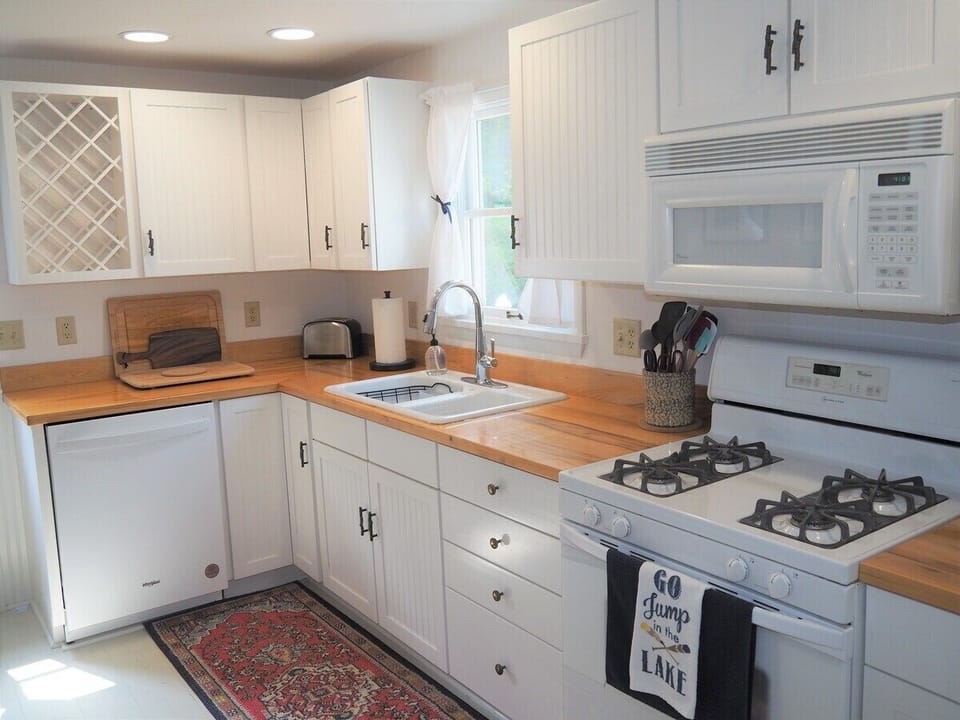 KITCHEN:  Looking into the large and modern kitchen, which includes all appliances (including a dishwasher and a gas range), lots of cupboard and counter space, a "coffee cabinet", and a good supply of cooking and dining utensils.