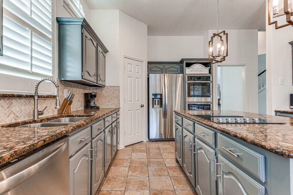 Clean and open kitchen, cabinets stocked with cookware and utensils 