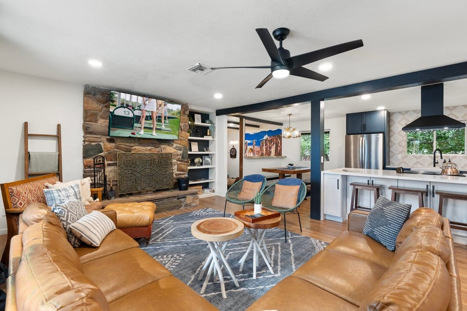 Living room with 65” Roku TV and wood burning fireplace. 