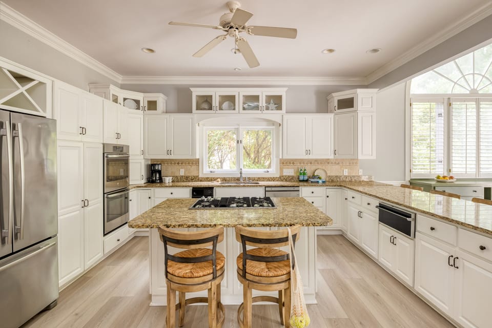 Spacious kitchen with a gas stovetop and barstool seating at the island.